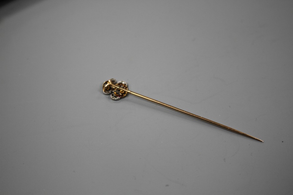 An early 20th century French yellow metal (poincon marks for 18ct), ruby and diamond stick pin, with ER? monogram terminal,